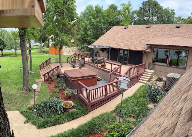 wooden deck featuring a lawn and a hot tub