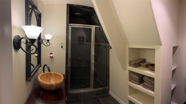 full bath with a sink, tile patterned flooring, and a stall shower