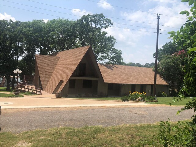 a-frame home featuring roof with shingles