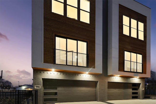 view of front of property with a balcony, an attached garage, and brick siding