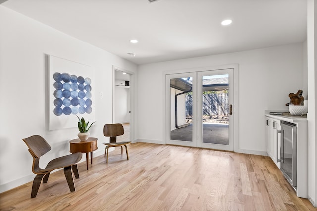 sitting room with recessed lighting, baseboards, beverage cooler, and light wood finished floors