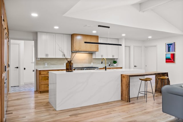 kitchen featuring light countertops, light wood-type flooring, and backsplash