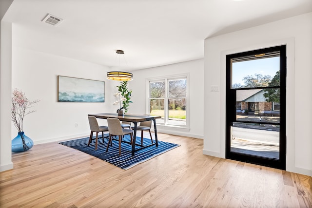 dining room with light wood-style floors, visible vents, and baseboards