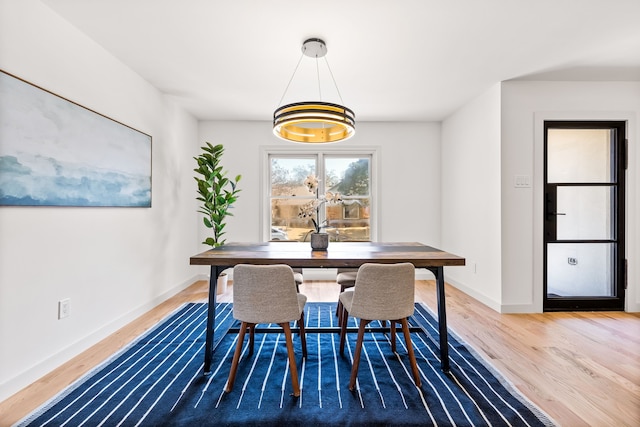 dining area with baseboards and wood finished floors