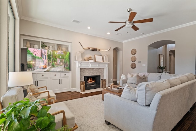 living area with dark wood finished floors, a fireplace with flush hearth, visible vents, and arched walkways