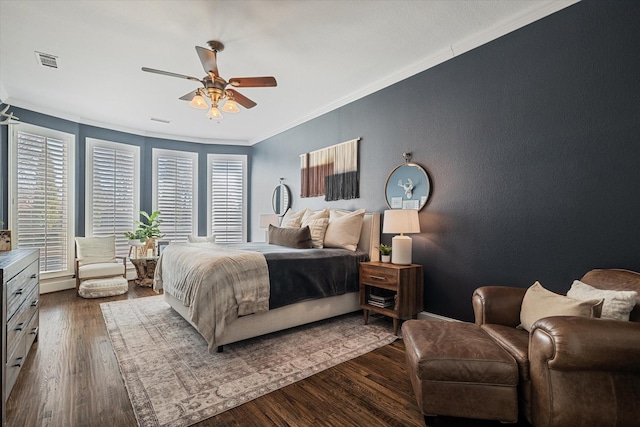 bedroom featuring ceiling fan, visible vents, dark wood finished floors, and crown molding