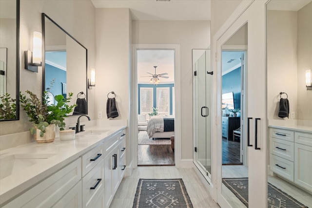 ensuite bathroom featuring a sink, connected bathroom, a shower stall, and double vanity