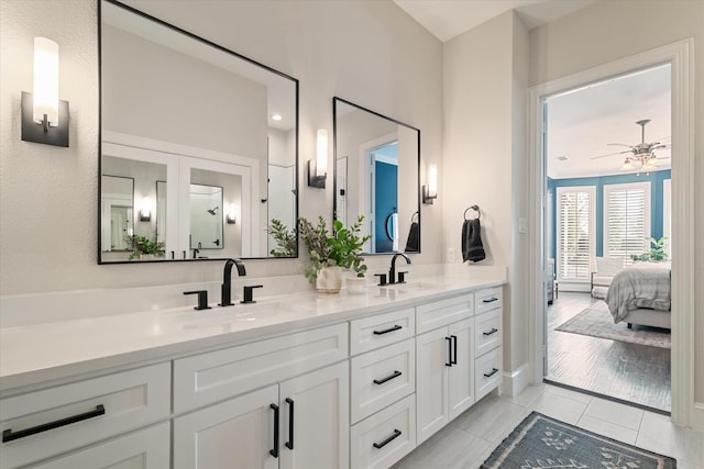 bathroom featuring tile patterned flooring, double vanity, ensuite bathroom, and a sink