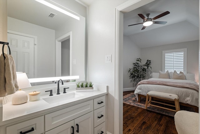 bedroom with visible vents, dark wood-type flooring, a sink, ceiling fan, and vaulted ceiling