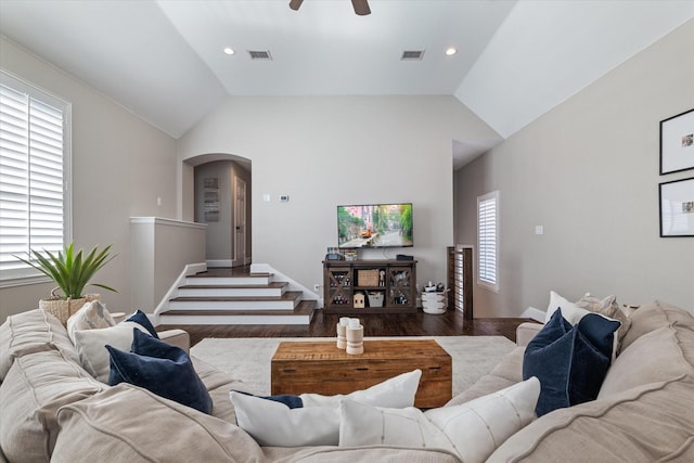 living room with vaulted ceiling, arched walkways, and visible vents