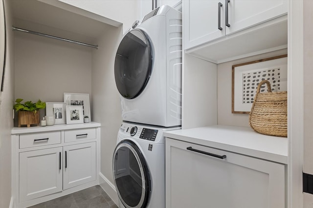 laundry area featuring cabinet space and stacked washing maching and dryer