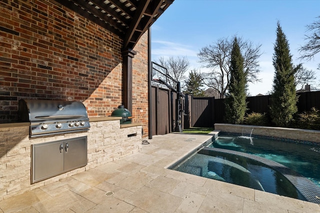 view of pool featuring a patio area, area for grilling, a fenced backyard, and exterior kitchen