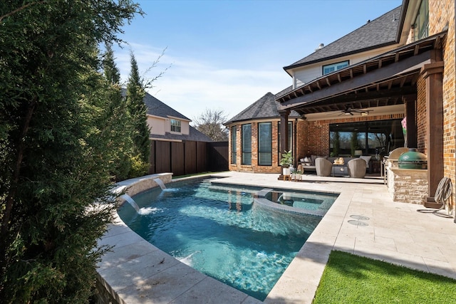 view of swimming pool featuring ceiling fan, fence, a patio area, area for grilling, and an outdoor kitchen