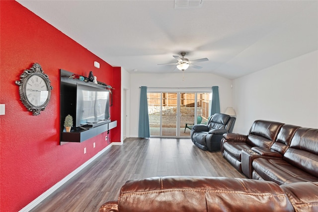 living area featuring wood finished floors, visible vents, baseboards, lofted ceiling, and ceiling fan