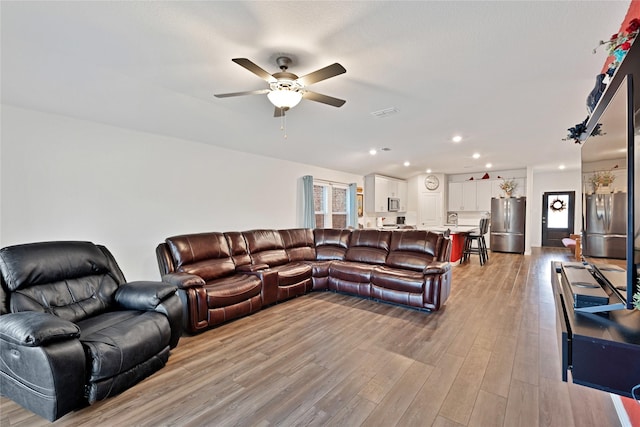 living room featuring recessed lighting, light wood-type flooring, and a ceiling fan