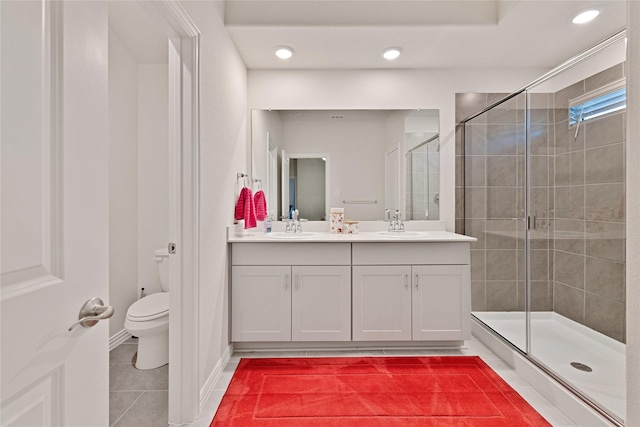 full bathroom featuring double vanity, a sink, a shower stall, tile patterned floors, and toilet