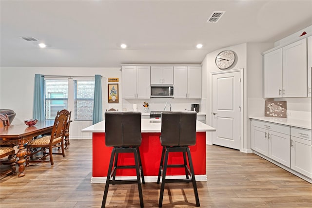 kitchen featuring visible vents, appliances with stainless steel finishes, light wood-type flooring, and light countertops