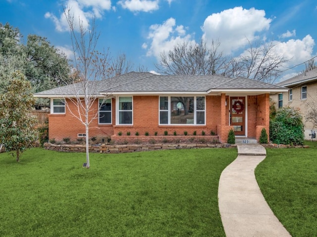 ranch-style home with a front lawn, brick siding, and roof with shingles