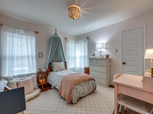 bedroom featuring light wood-type flooring, multiple windows, and wallpapered walls