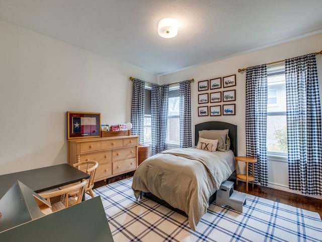 bedroom with multiple windows and light wood-type flooring