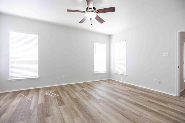 unfurnished room with a ceiling fan, light wood-style floors, and baseboards