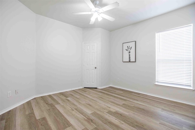 empty room with baseboards, ceiling fan, and wood finished floors