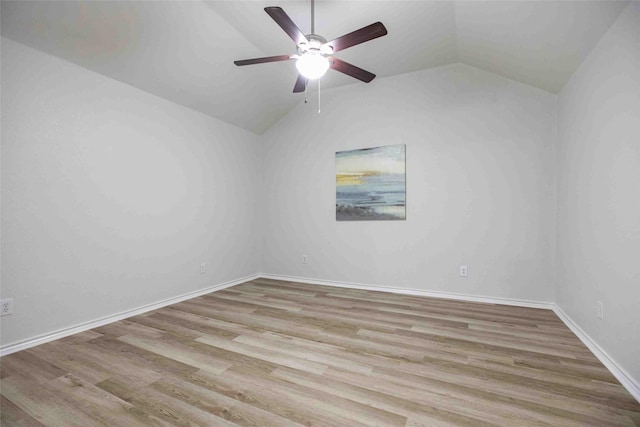 spare room with lofted ceiling, wood finished floors, baseboards, and ceiling fan