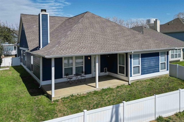 back of property featuring a lawn, a chimney, a fenced backyard, a sunroom, and a patio