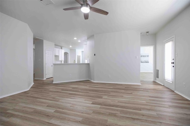 unfurnished living room featuring visible vents, baseboards, light wood-style floors, and ceiling fan