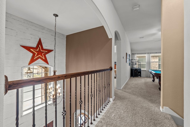 hallway with baseboards, carpet floors, arched walkways, and visible vents