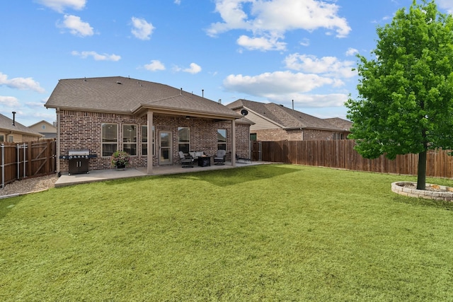 back of property featuring a patio, brick siding, a fenced backyard, and a lawn