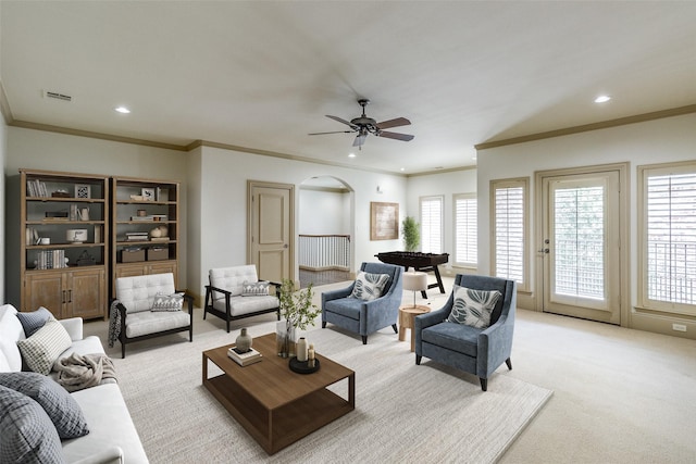 living area with visible vents, recessed lighting, arched walkways, crown molding, and light colored carpet