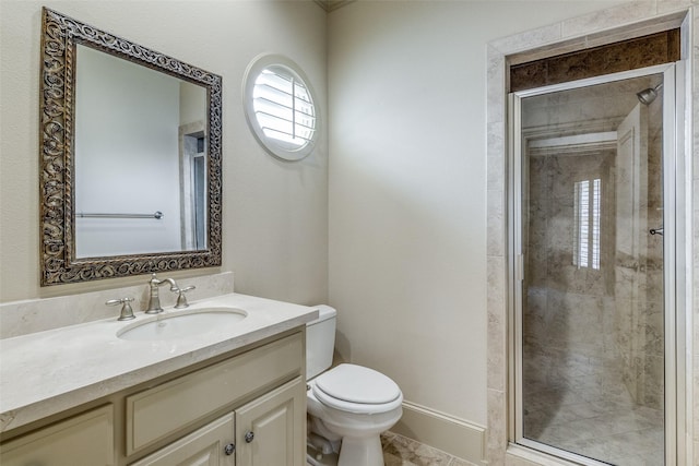 bathroom featuring a shower stall, toilet, vanity, and baseboards