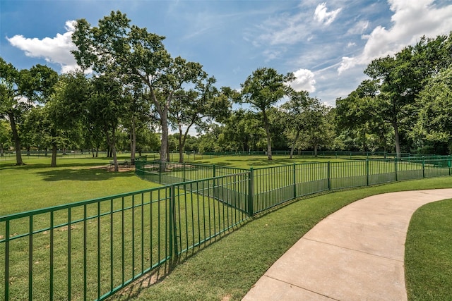 surrounding community with a lawn and fence