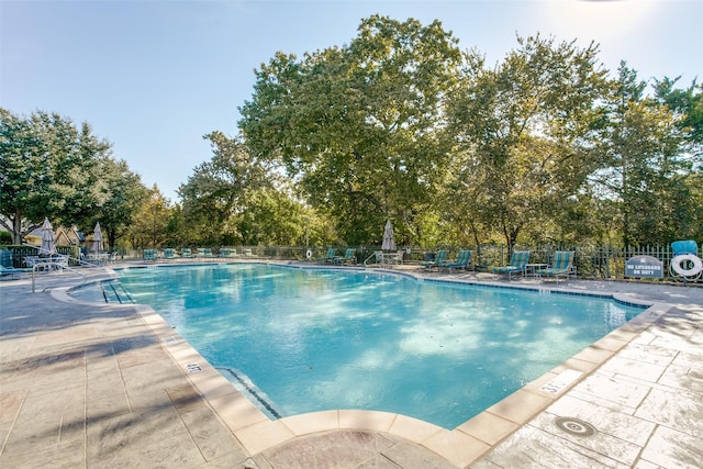 community pool featuring a patio area and fence