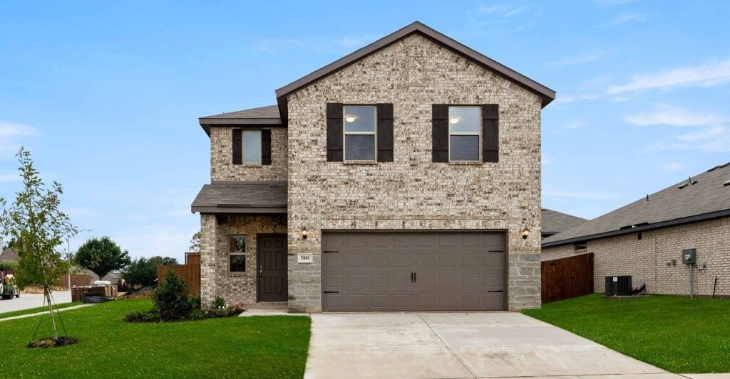 view of front of home featuring brick siding, central air condition unit, concrete driveway, and a front yard