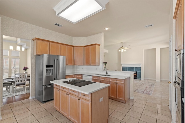 kitchen with visible vents, a peninsula, a sink, stainless steel appliances, and open floor plan