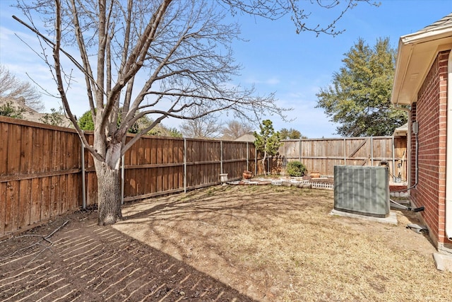 view of yard with central AC unit and a fenced backyard