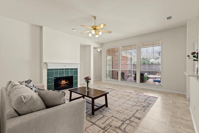 living area featuring visible vents, baseboards, ceiling fan, light tile patterned floors, and a fireplace