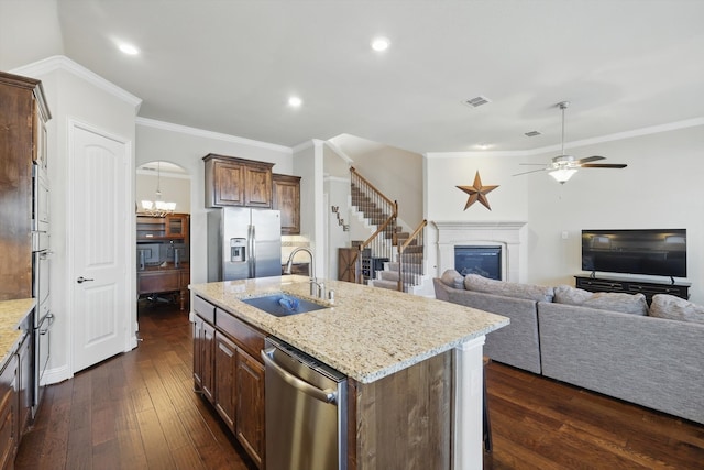 kitchen featuring visible vents, a sink, dark wood-type flooring, appliances with stainless steel finishes, and a glass covered fireplace