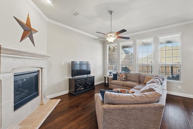 living room with visible vents, baseboards, ornamental molding, dark wood-type flooring, and a tiled fireplace