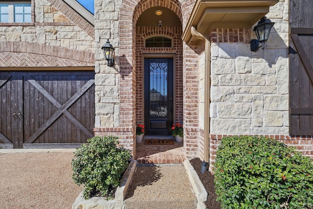 doorway to property with stone siding and brick siding