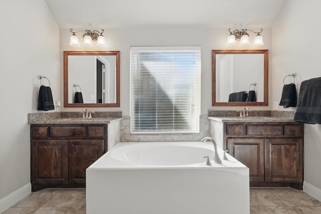 bathroom featuring a bath, two vanities, baseboards, and a sink