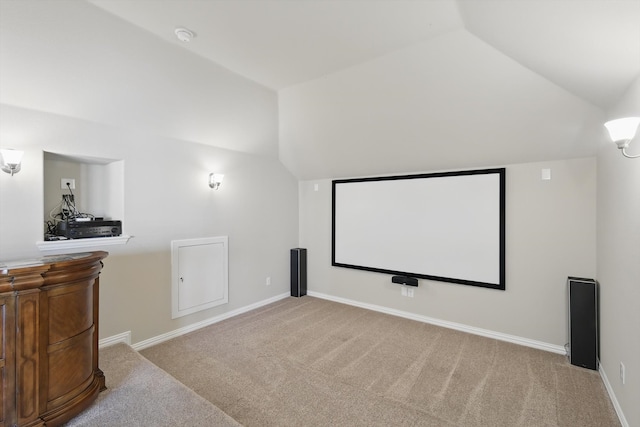 home theater featuring baseboards, carpet, and vaulted ceiling