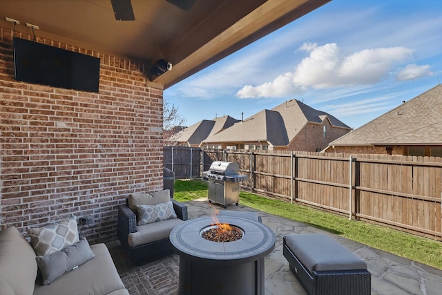 view of patio / terrace featuring area for grilling, a fenced backyard, and an outdoor living space with a fire pit