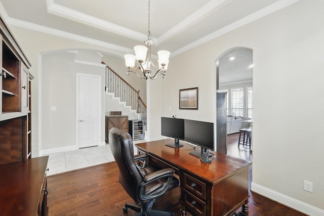 home office with arched walkways, ornamental molding, a tray ceiling, and wood finished floors