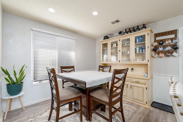 dining room featuring visible vents, recessed lighting, a textured ceiling, and light wood-style floors