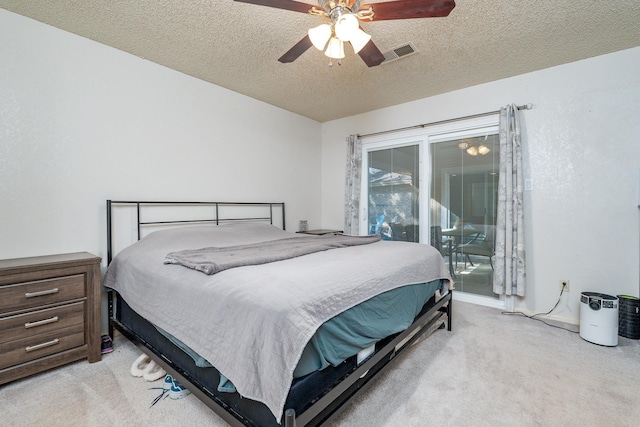 bedroom featuring visible vents, light carpet, a textured ceiling, and access to exterior