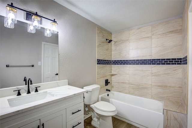 bathroom with vanity, a textured wall, wood finished floors, toilet, and washtub / shower combination