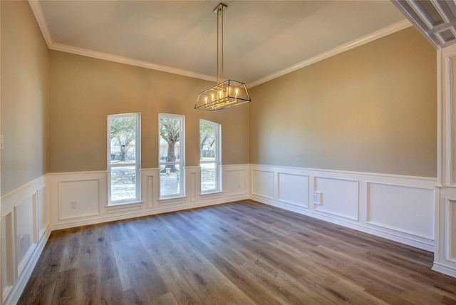 unfurnished dining area featuring ornamental molding, a decorative wall, a wainscoted wall, and dark wood-style floors